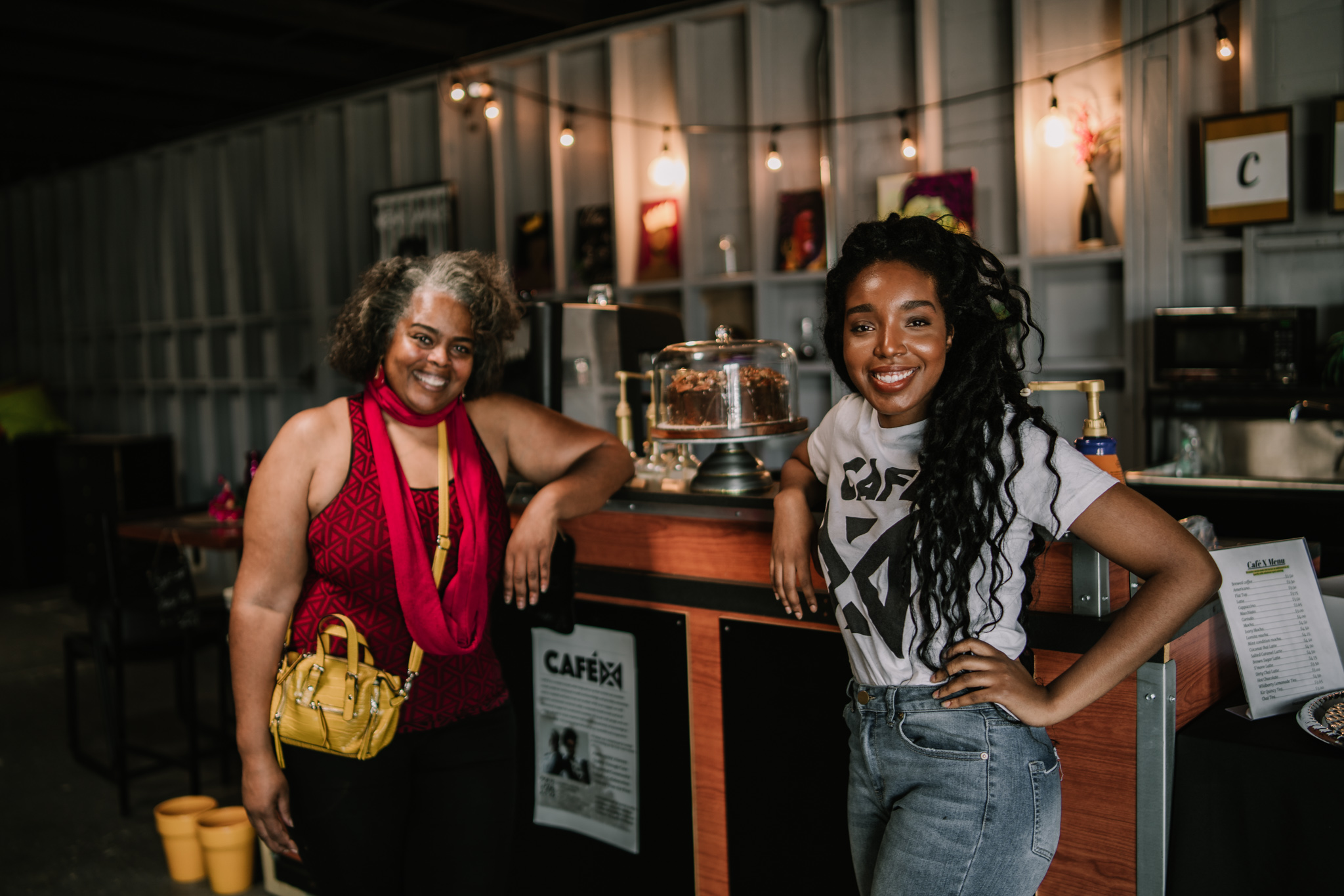 Cafe X owners, Cynthia and Khea, standing at the counter inside their store